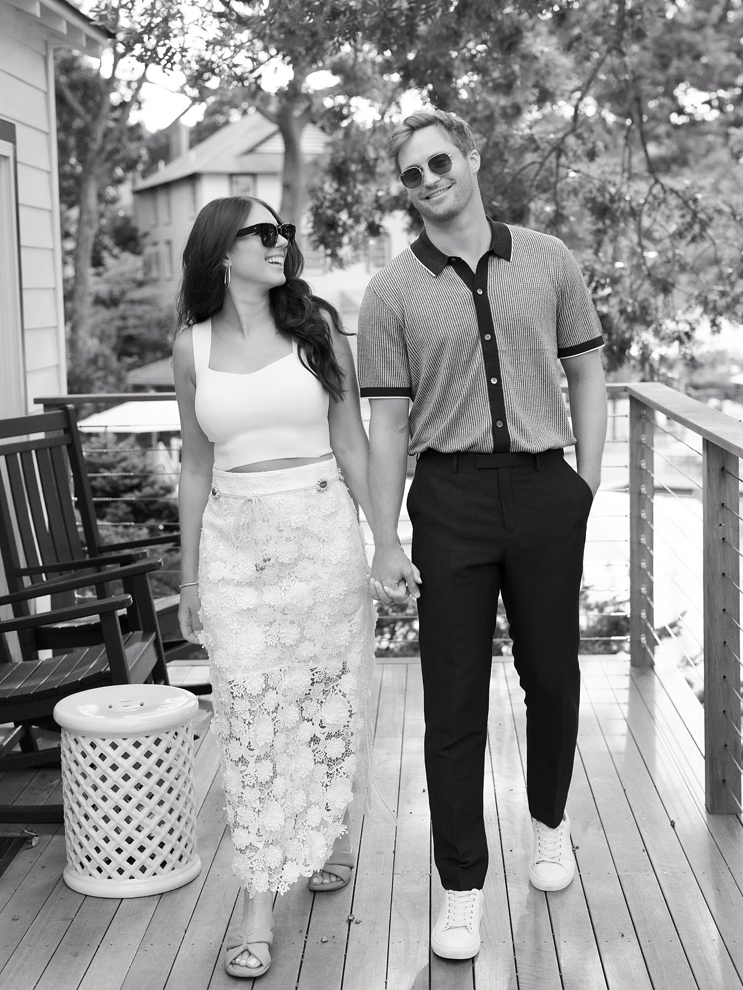 engaged couple holds hands walking on wooden deck at the Pridwin on Shelter Island NY