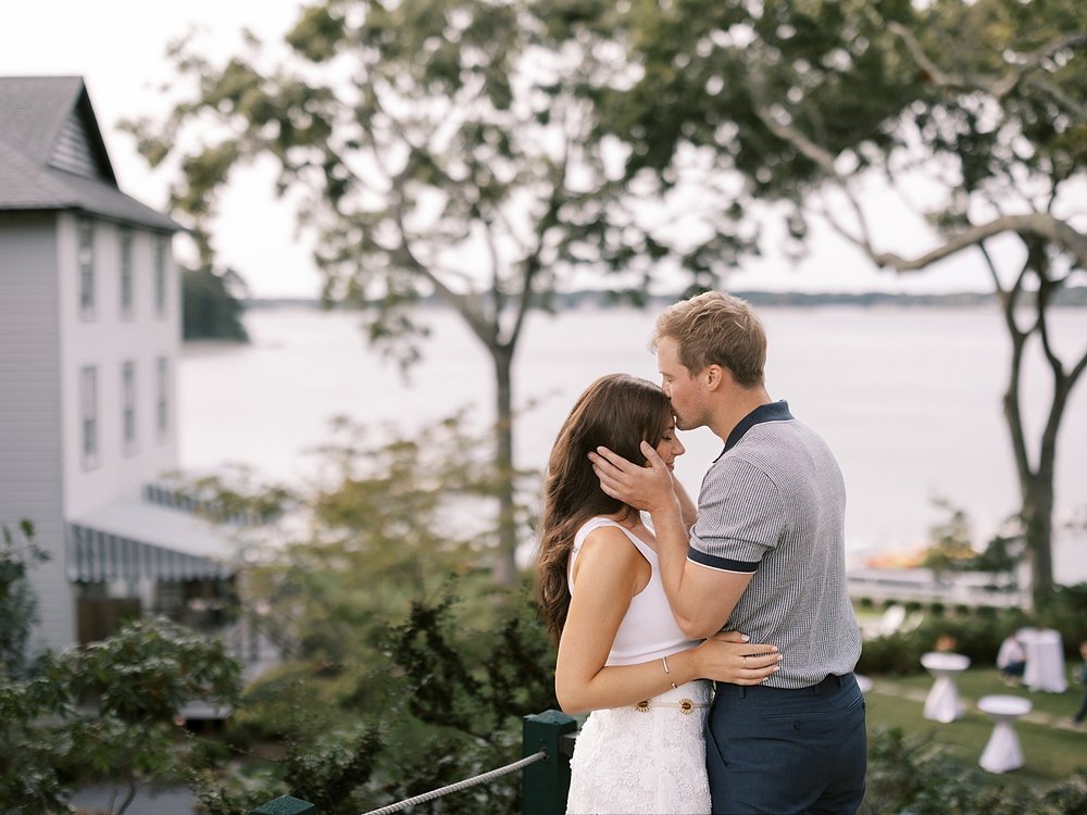 man kisses woman on head during engagement session at the Pridwin on Shelter Island NY