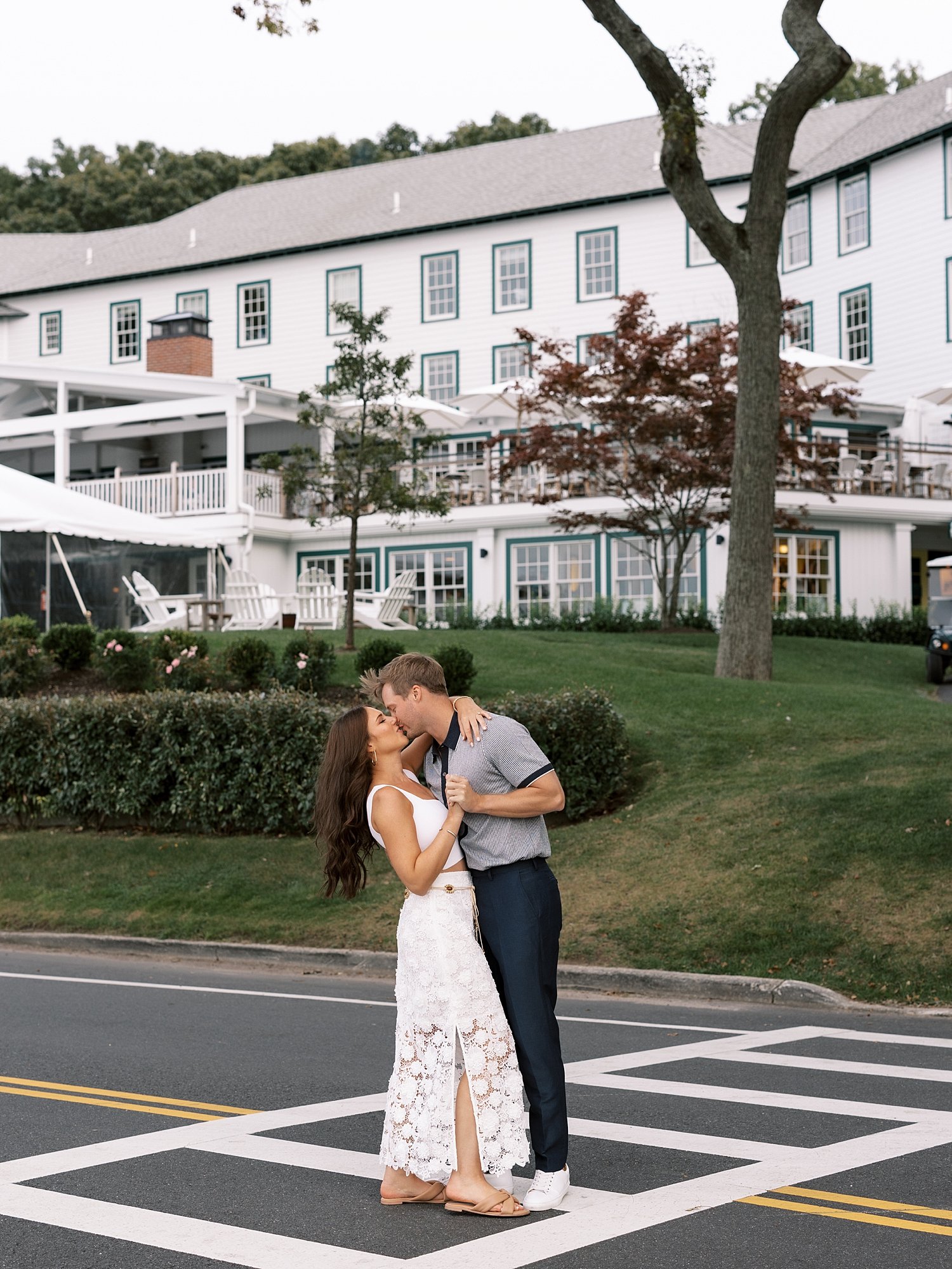 man and woman kiss in crosswalk outside historic NY hotel