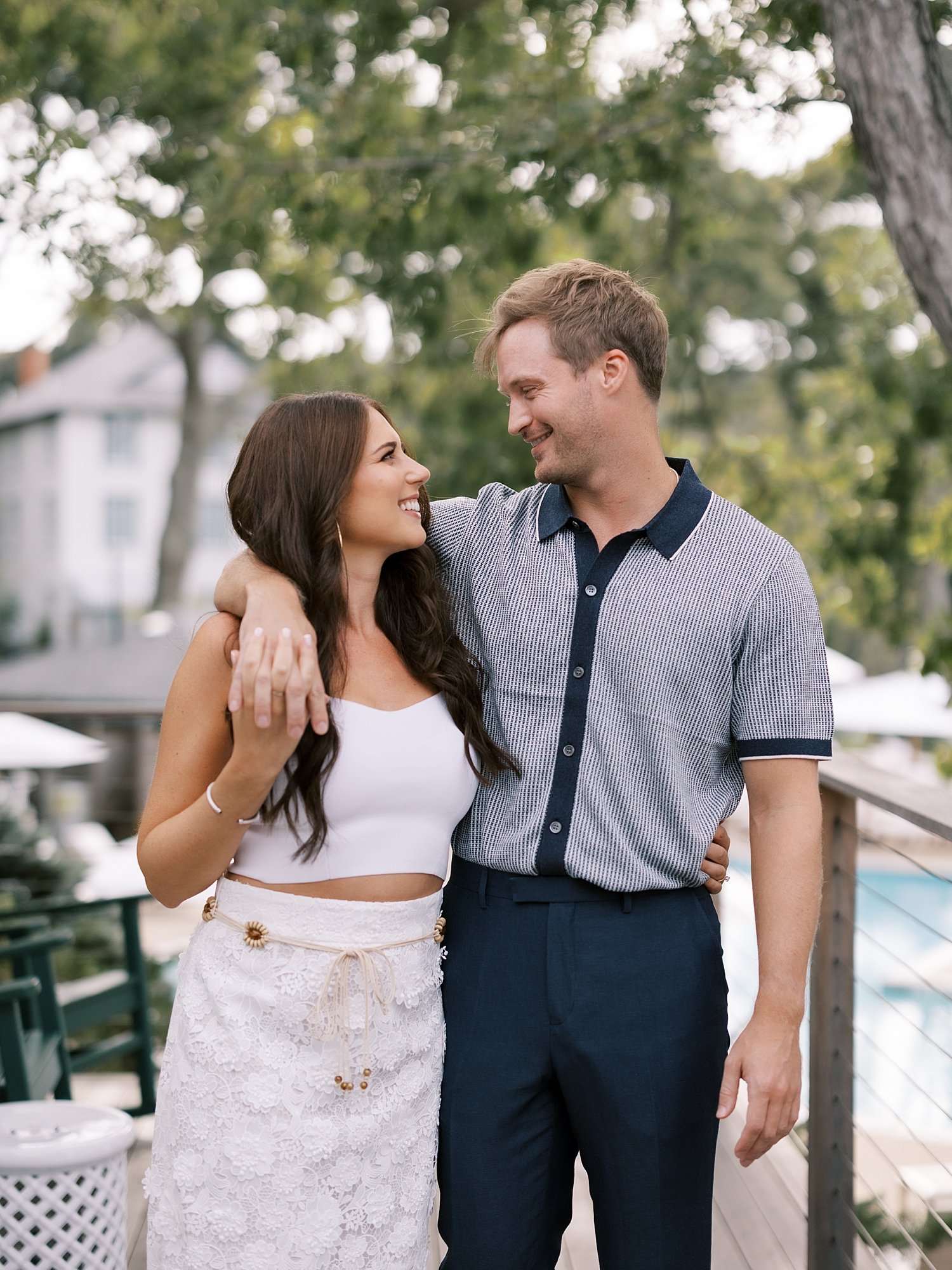 man hugs woman around neck smiling together outside Shelter Island hotel