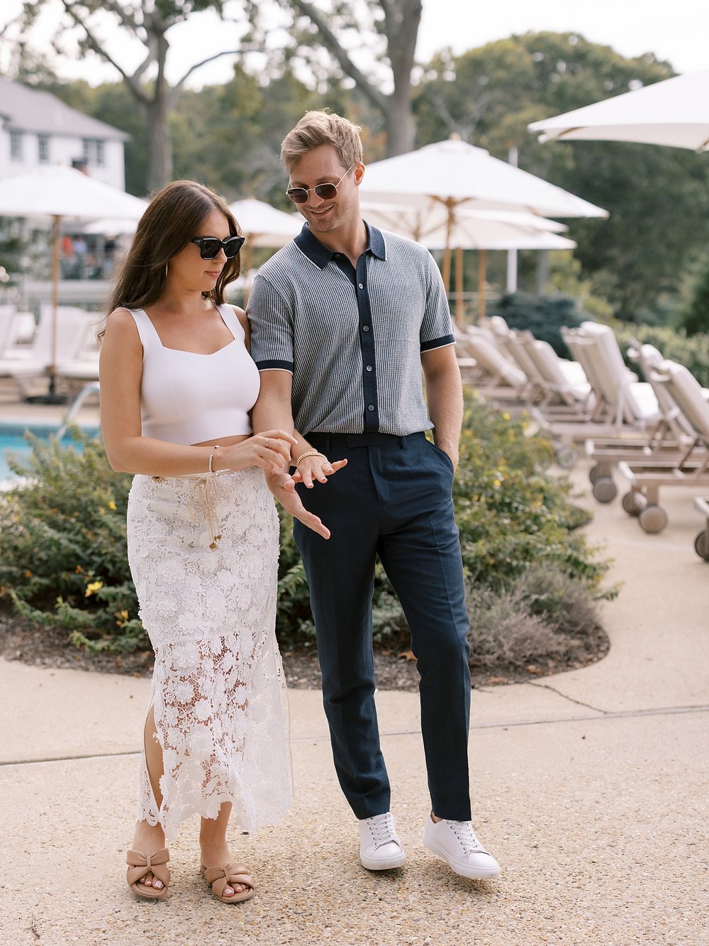 man and woman talk walking around pool at Shelter Island hotel