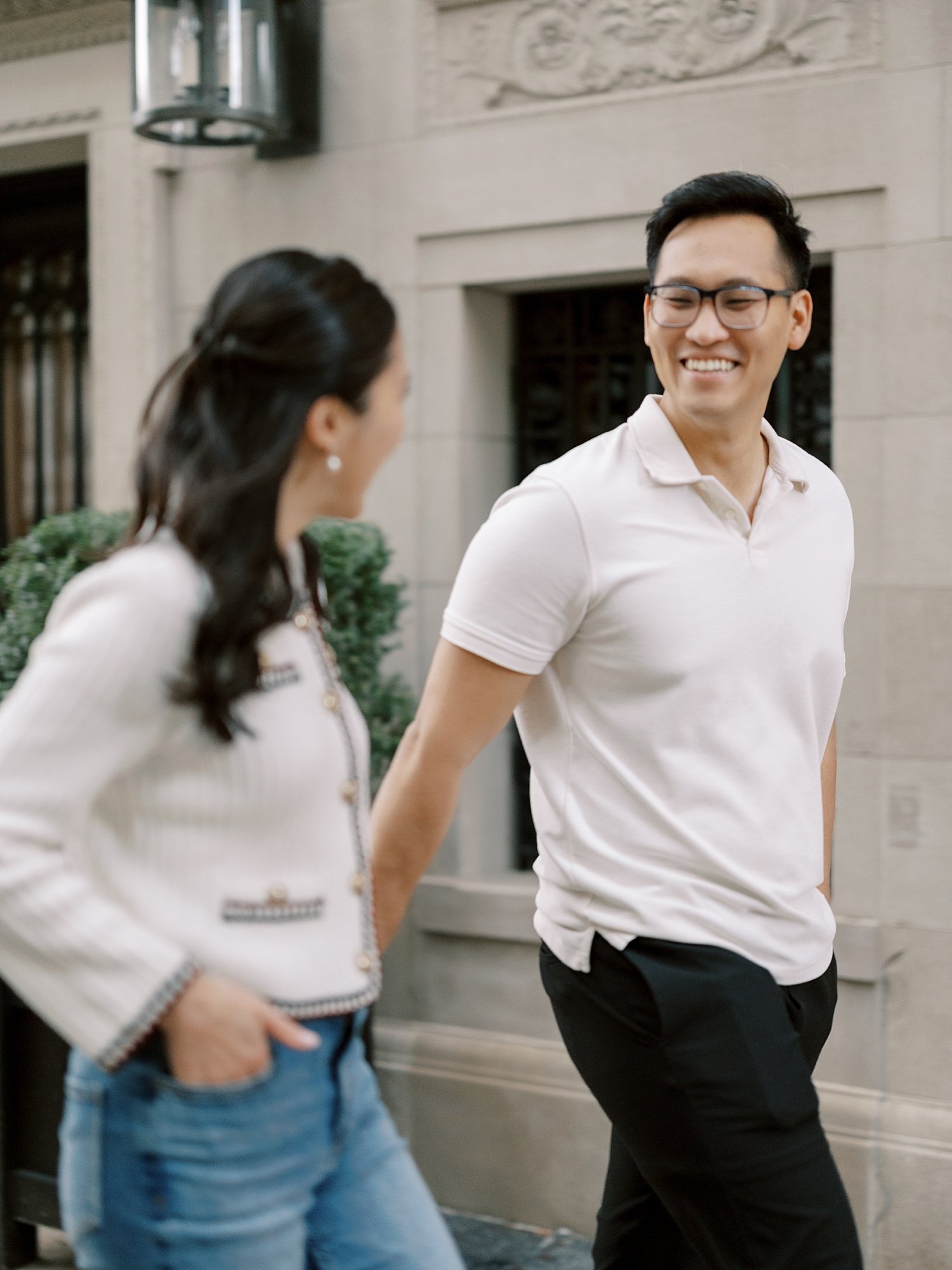 engaged couple holds hands walking on the Upper East Side in NYC