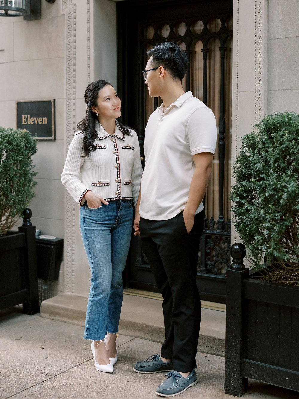 woman stands with hands in pocket of jeans standing with man on the Upper East Side in NYC