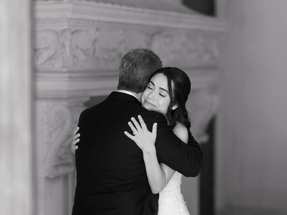 bride and groom hug during first look by fireplace inside the Mansion at Natirar