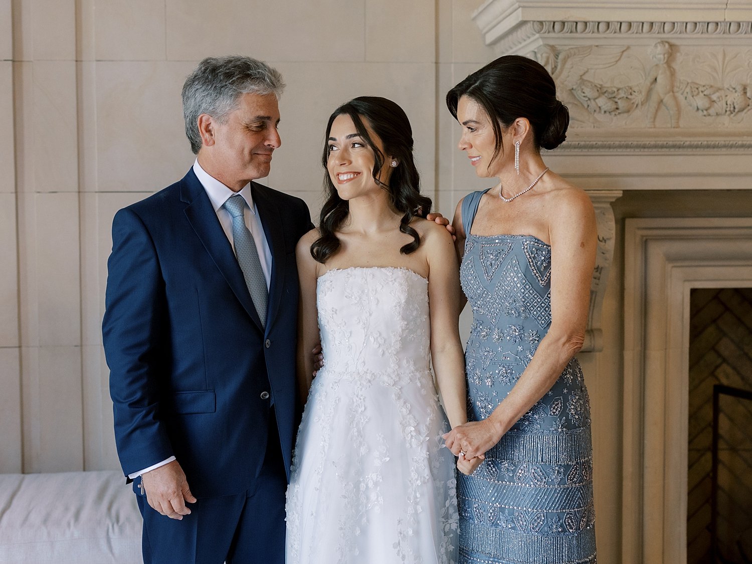 bride smiles with parents inside library at the Mansion at Natirar