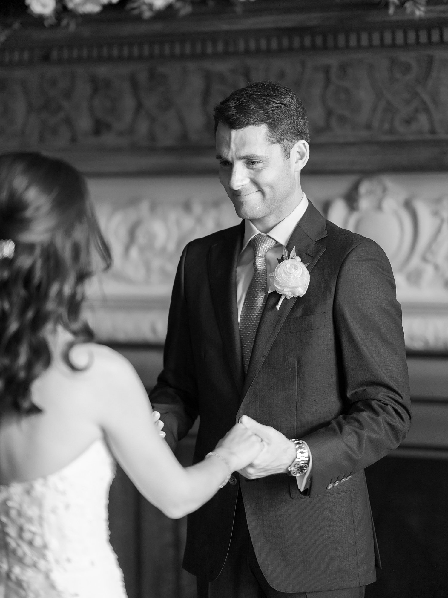 groom smiles at bride inside library of the Mansion at Natirar