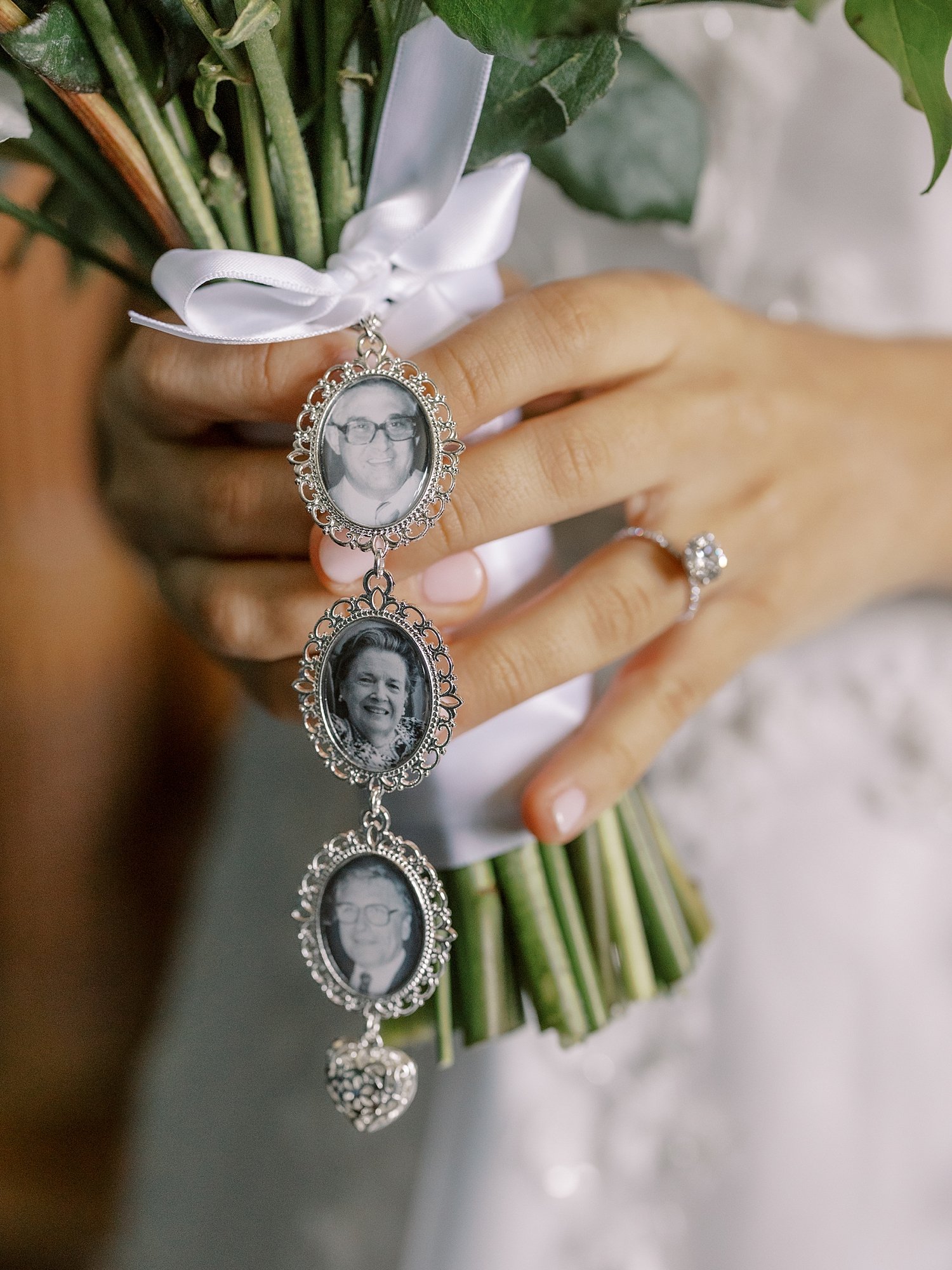 bride holds bouquet with hanging photo charms
