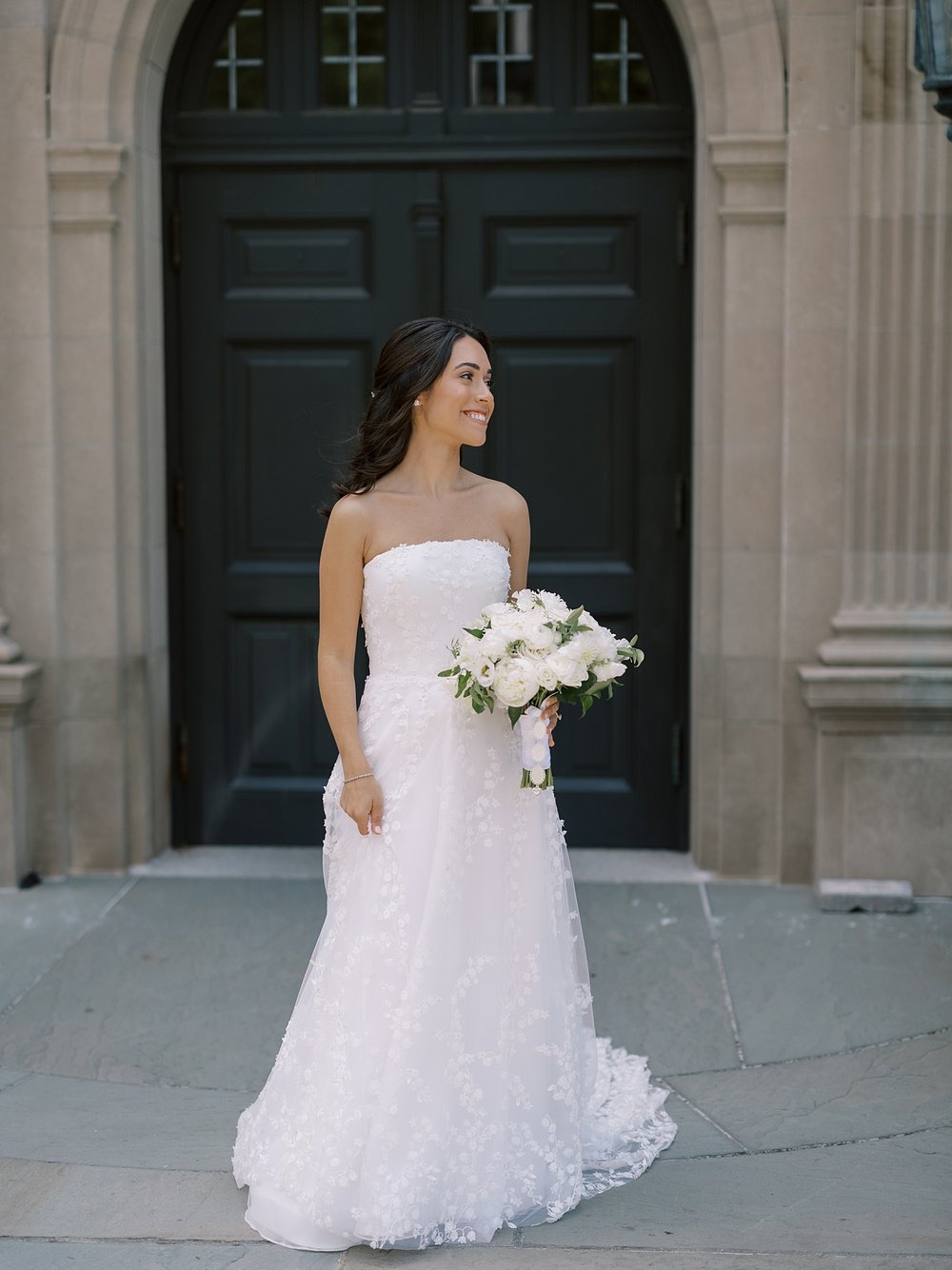 bride poses in front of black doors outside the Mansion at Natirar