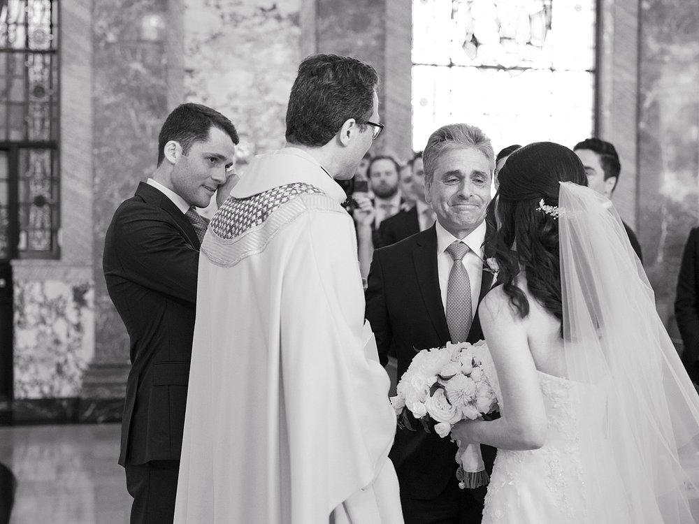bride and father smile near groom before ceremony inside the chapel at the Villa Walsh Academy