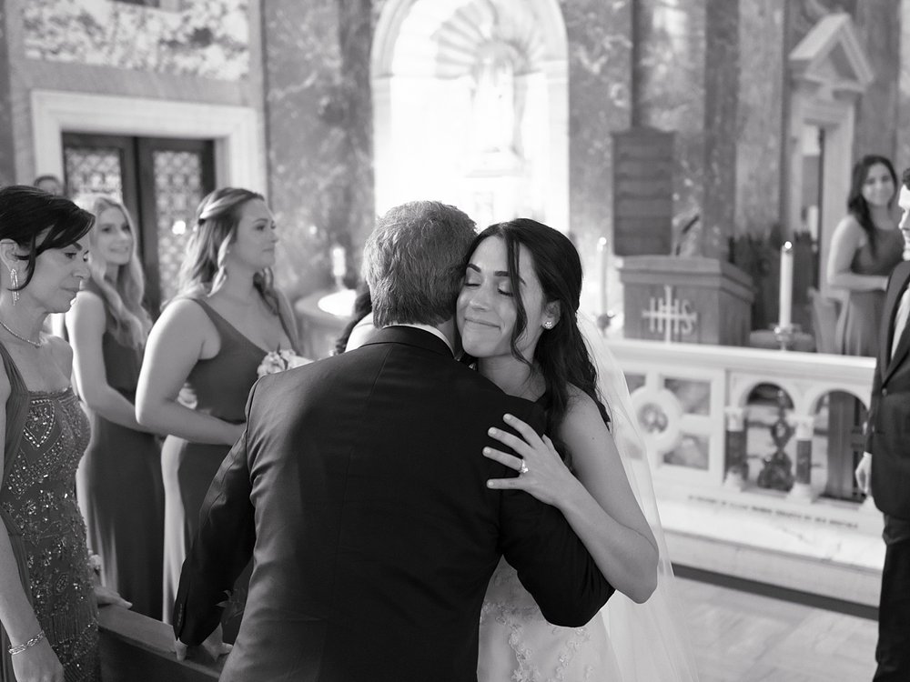 bride hugs father after ceremony inside the chapel at the Villa Walsh Academy