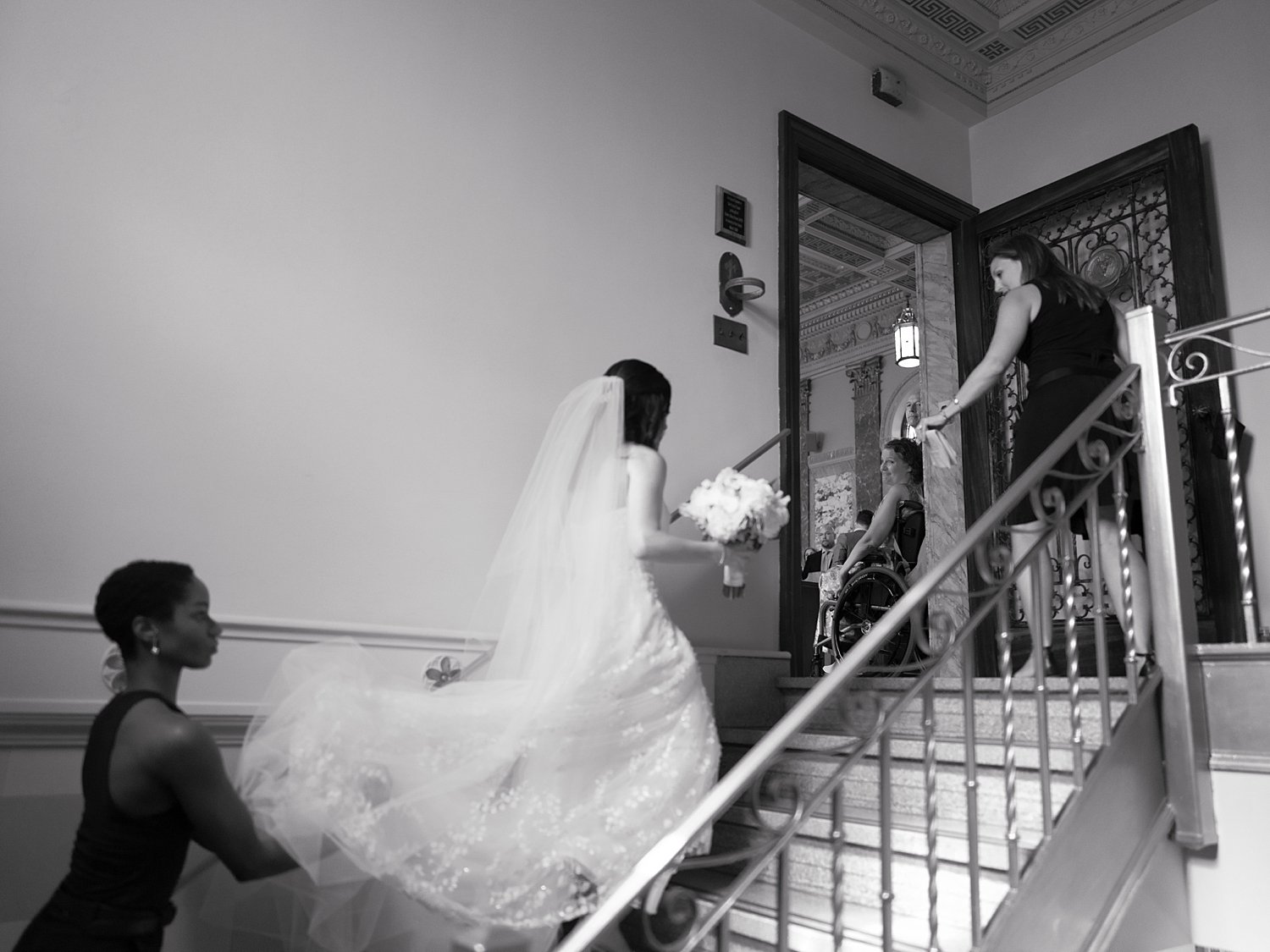 bride walks up steps with bridesmaids inside Pendry Natirar