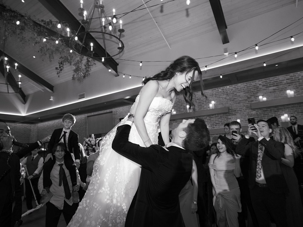 groom lifts up bride during NJ wedding reception 