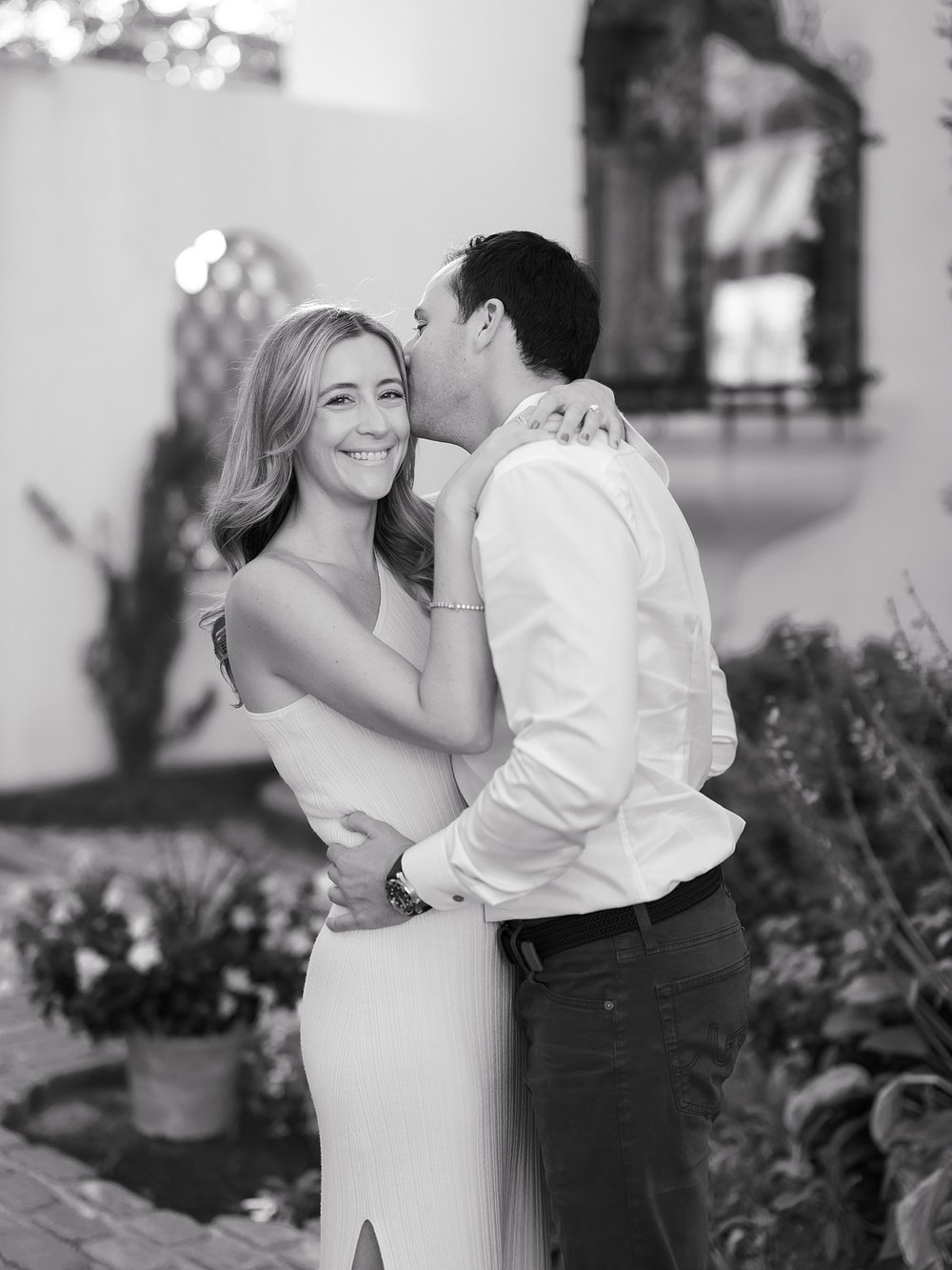 man leans to kiss woman's cheek during engagement session at the Vanderbilt Museum