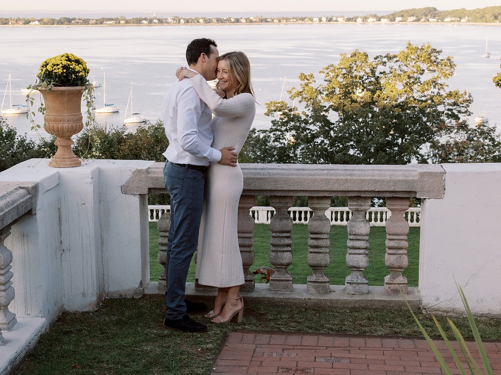 bride and groom hug at sunset on the patio at the Vanderbilt Museum