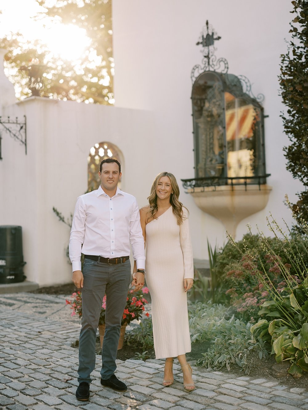 bride and groom hold hands walking through the Vanderbilt Museum at sunset