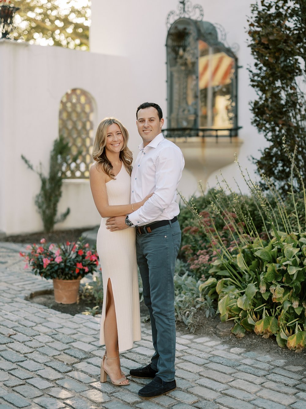 man hugs woman around middle standing on patio at the Vanderbilt Museum