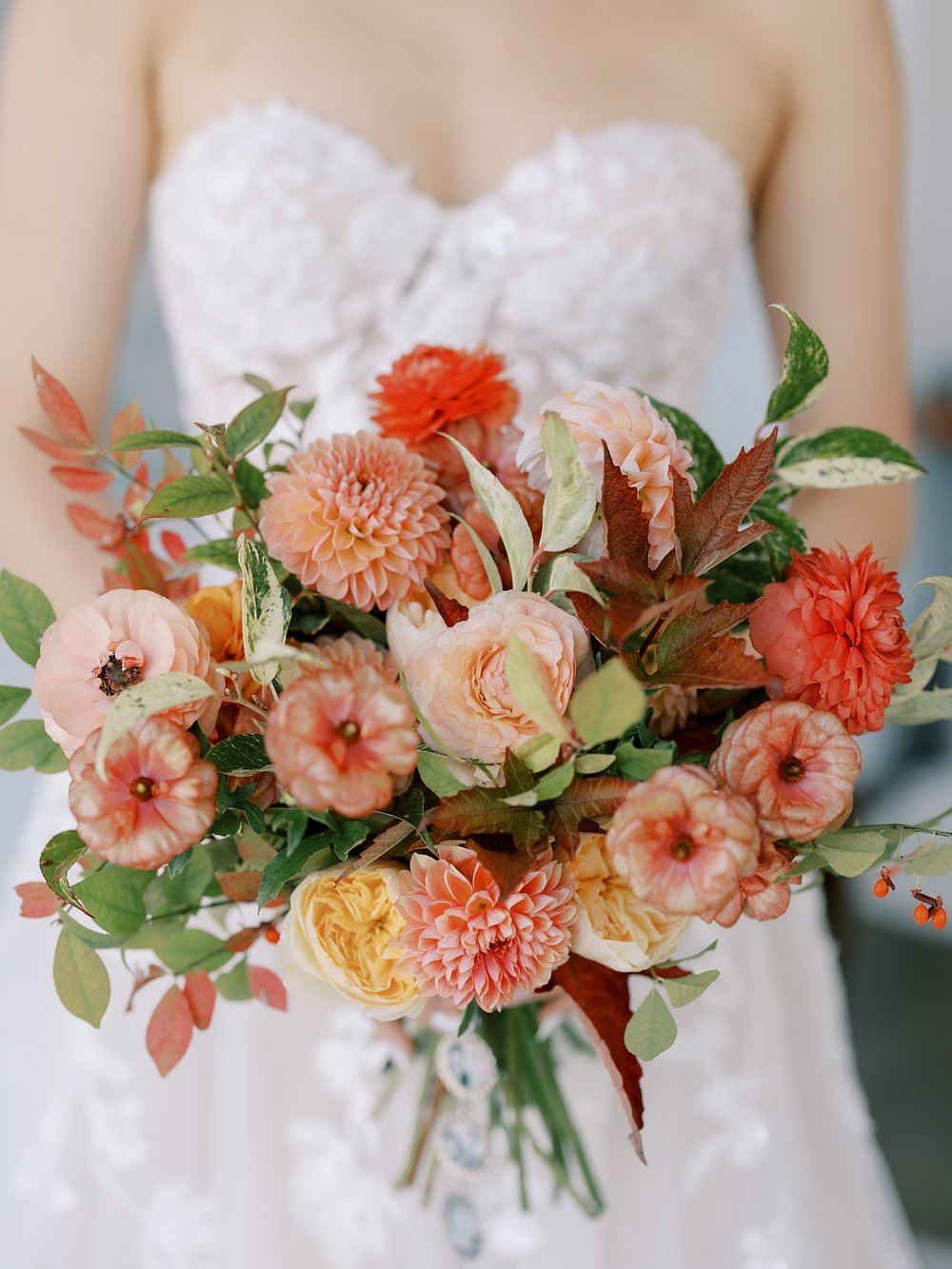 bride in strapless gown holds bouquet of bright flowers at the Wythe Hotel in Brooklyn NY