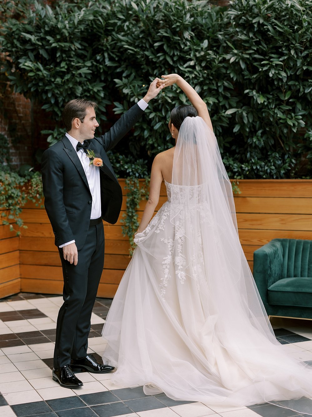 groom twirls bride under his arm during first look at the Wythe Hotel in Brooklyn NY