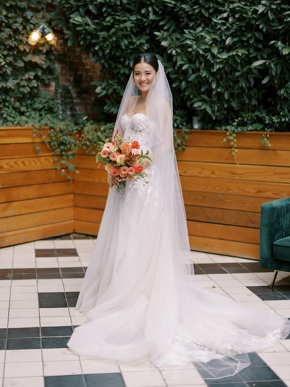 bride holds bouquet of coral and yellow flowers at the Wythe Hotel