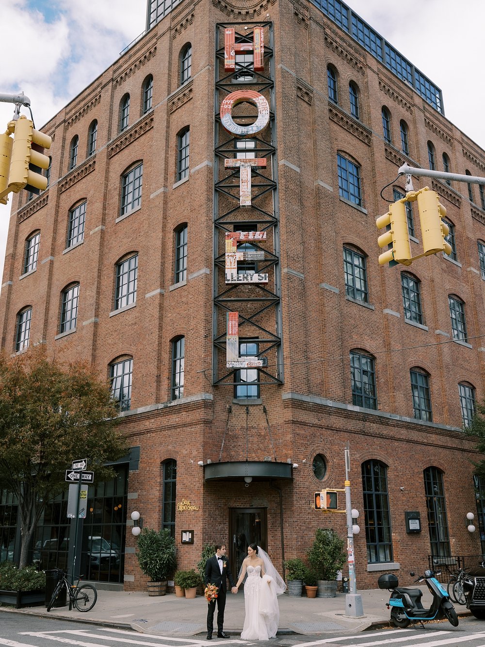 couple stands on corner outside the Wythe Hotel