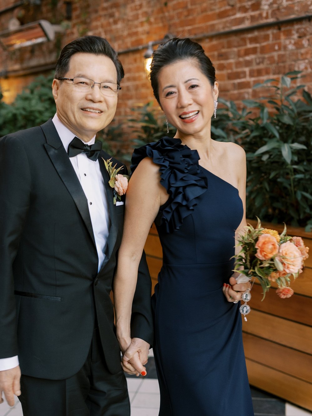 parents hold hands walking through the Wythe Hotel on wedding day 