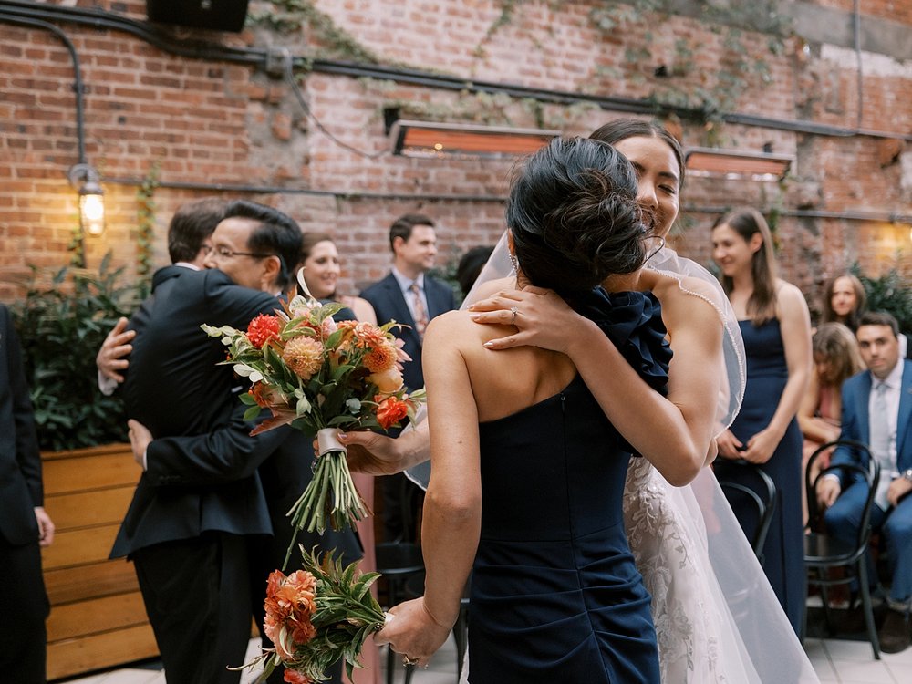 bride and groom hug parents during ceremony at the Wythe Hotel