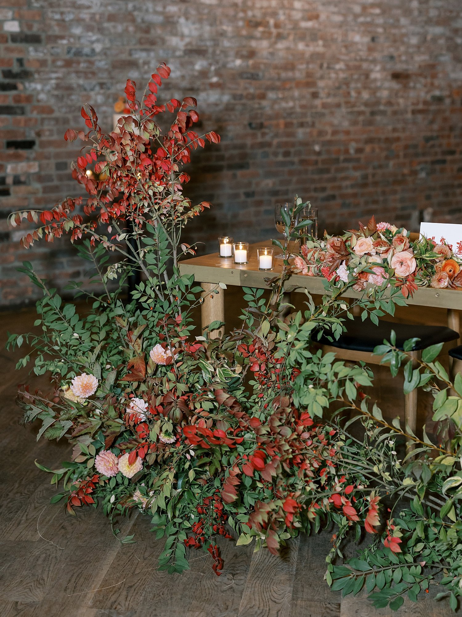 red flowers lean against sweetheart table at the Wythe Hotel