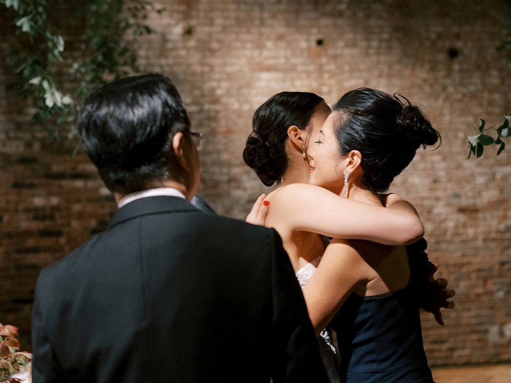 bride hugs family during Brooklyn NY wedding reception