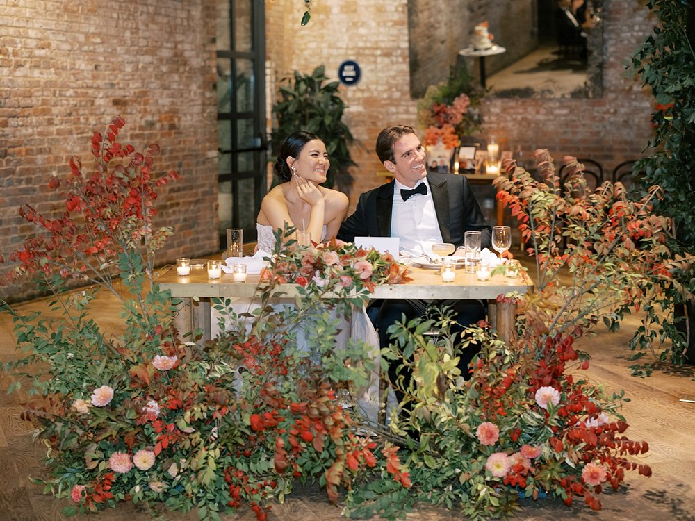 bride and groom sit at sweetheart table during Brooklyn NY wedding reception