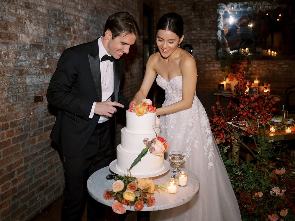 bride and groom cut wedding cake during Brooklyn NY wedding reception