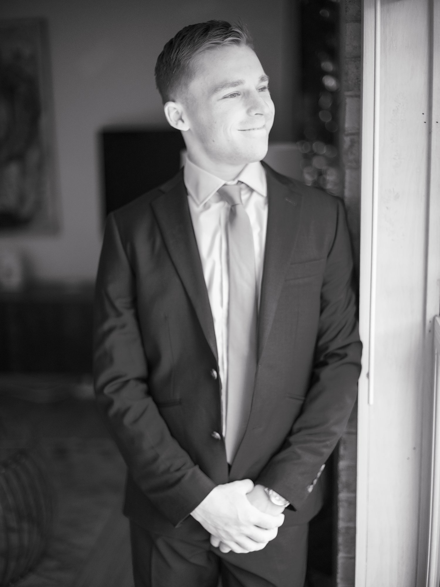 groom leans on wall inside the Buttermilk Inn &amp; Spa