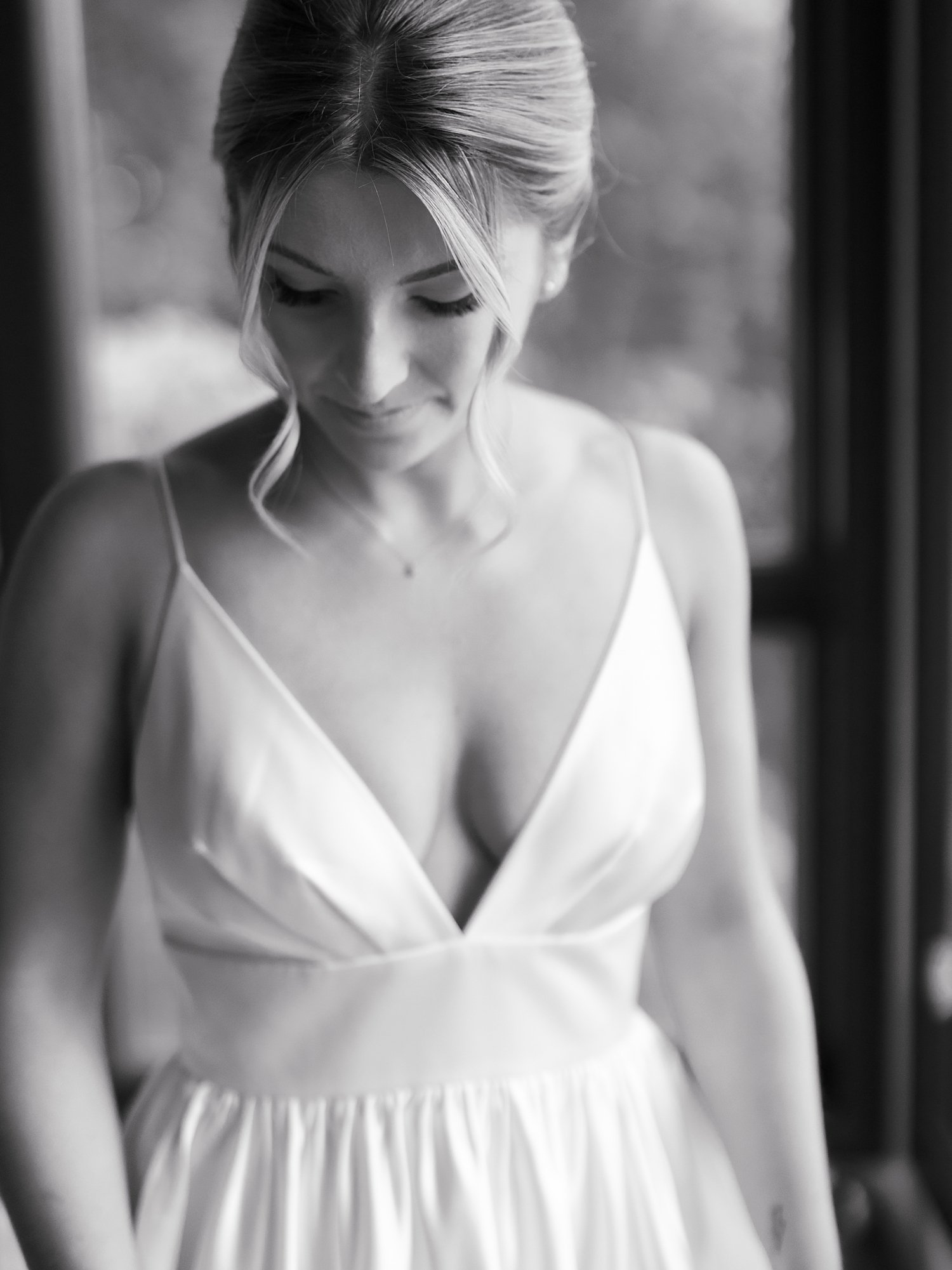 black and white portrait of bride looking down in wedding gown