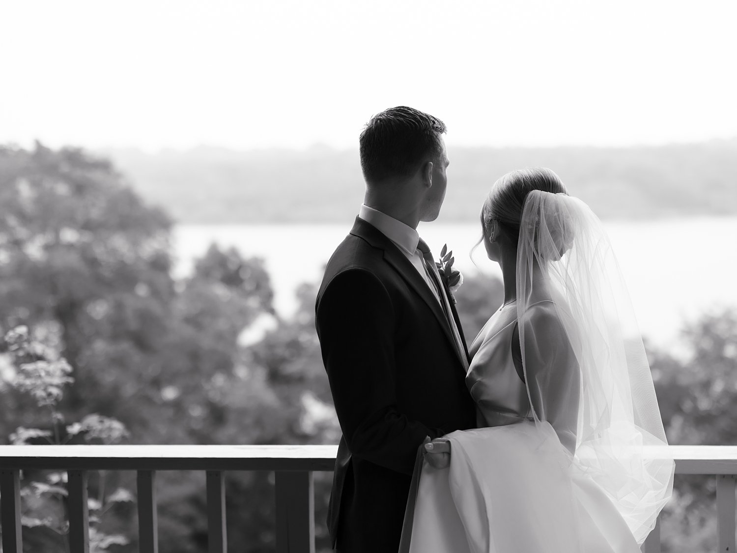 bride and groom hug on balcony at the Buttermilk Inn &amp; Spa