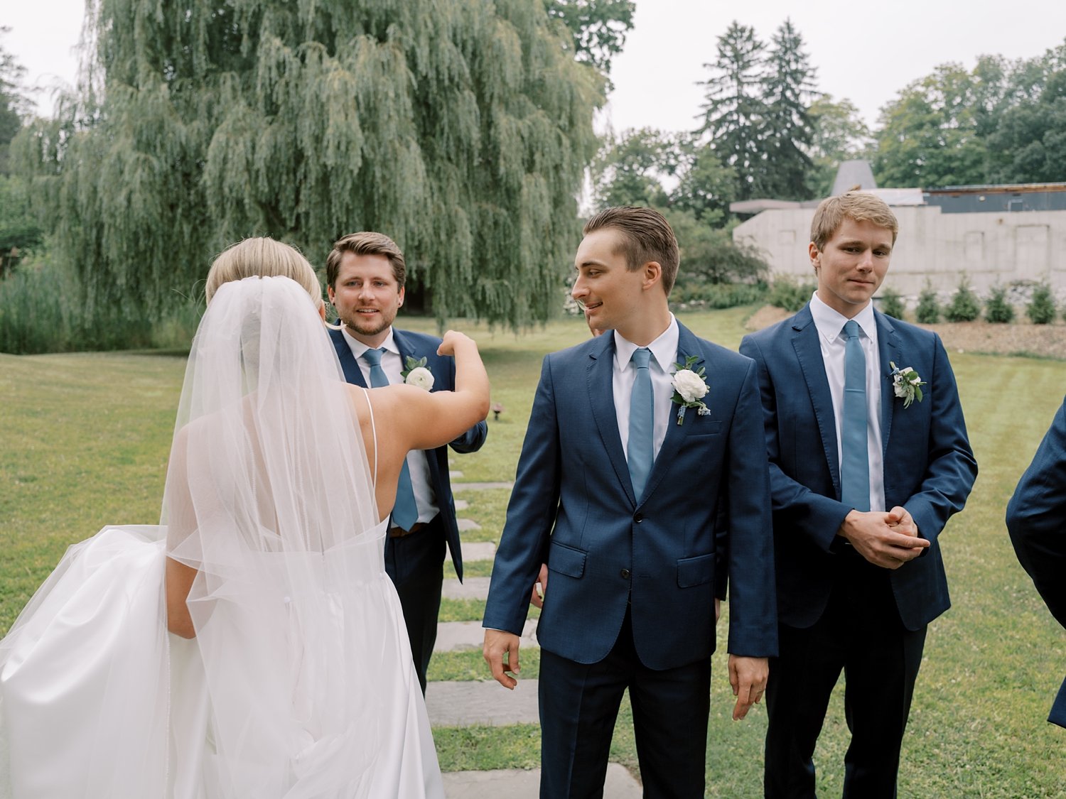 bride hugs groomsmen after first look