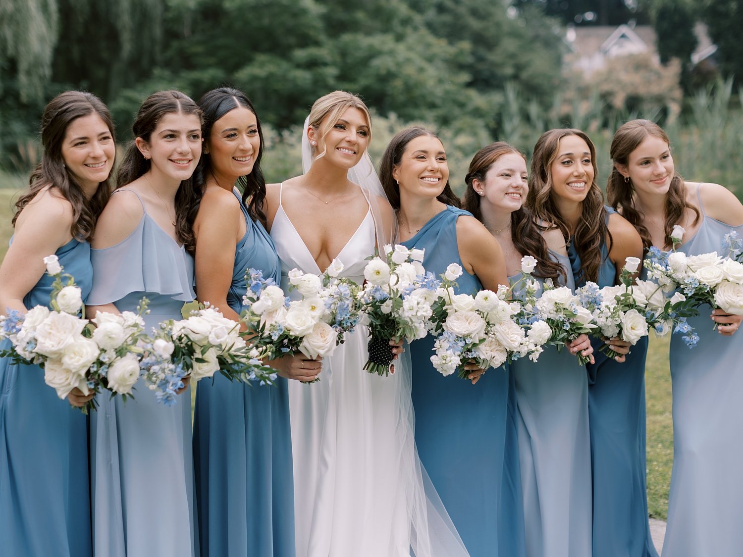 bride poses with bridesmaids in light blue gowns at the Buttermilk Inn &amp; Spa