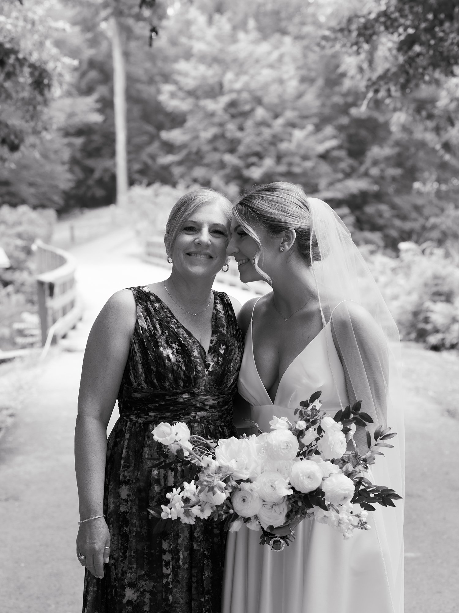 bride hugs mom leaning head into her forehead 