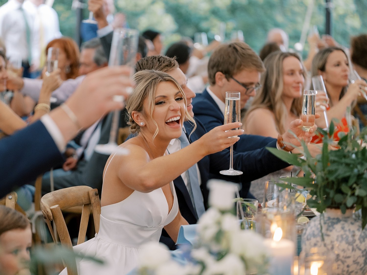 bride lifts up glass of champagne during reception in Milton NY