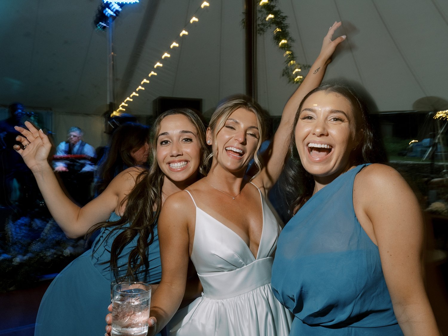 bride dances with bridesmaids in light blue gowns