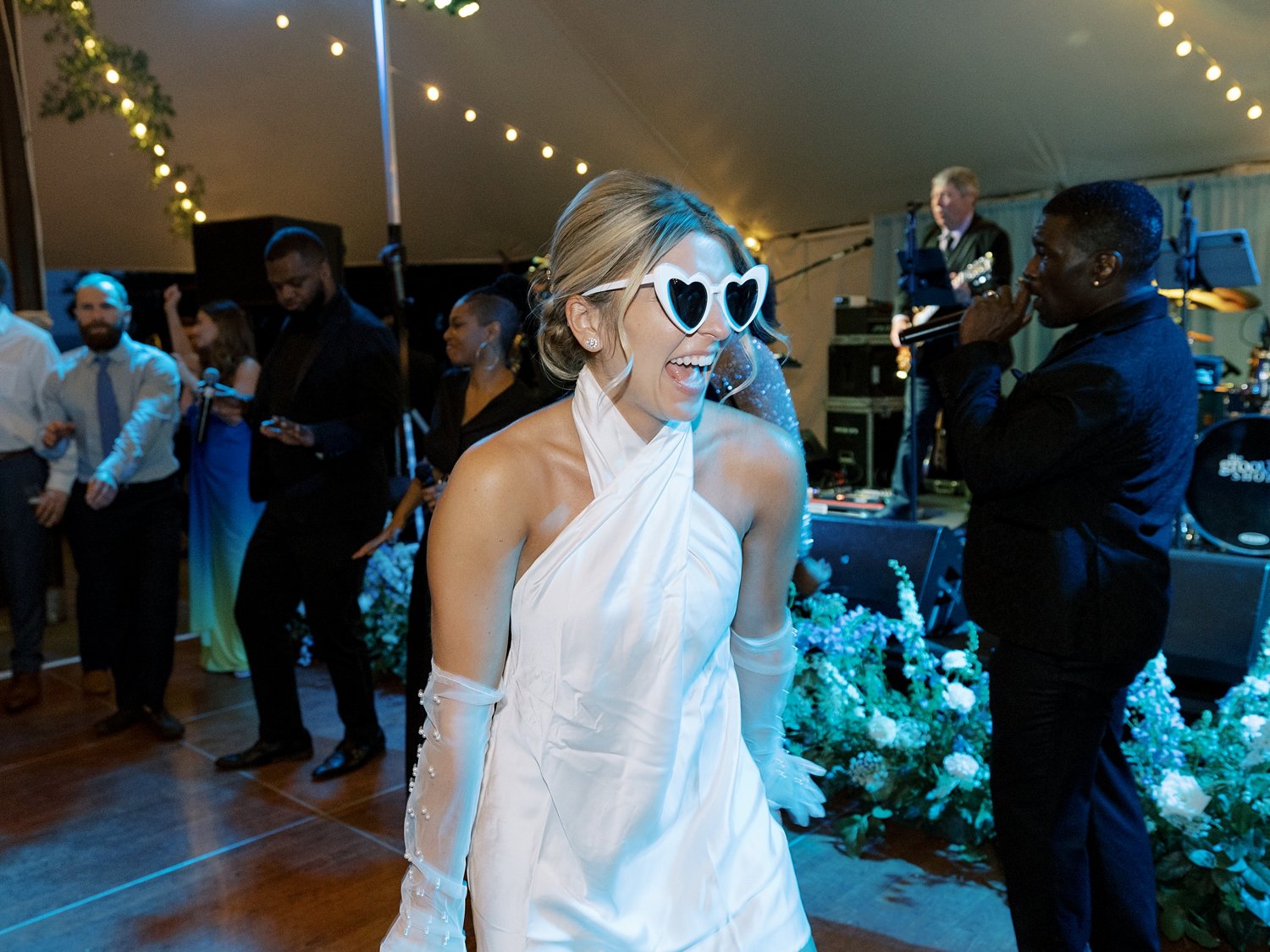 bride dances in short white dress with white sunglasses 