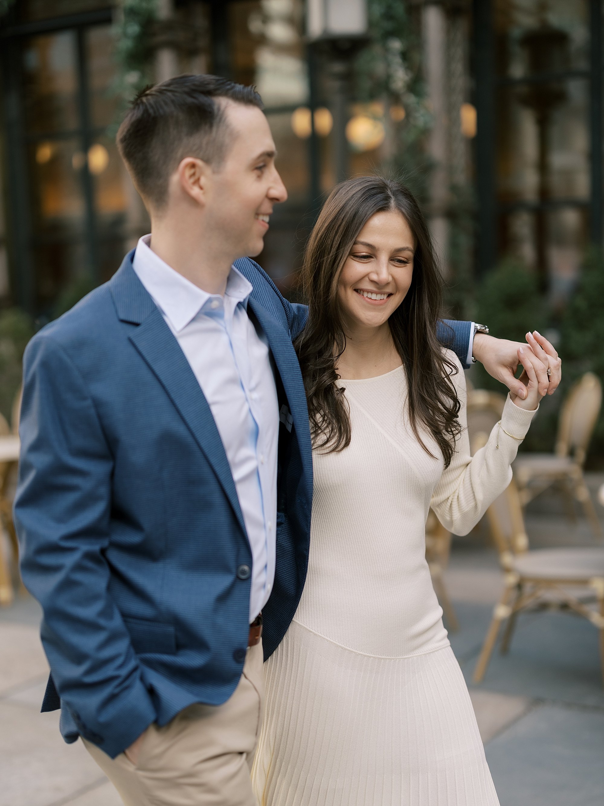 couple walks outside Bryant Park Cafe during engagement session