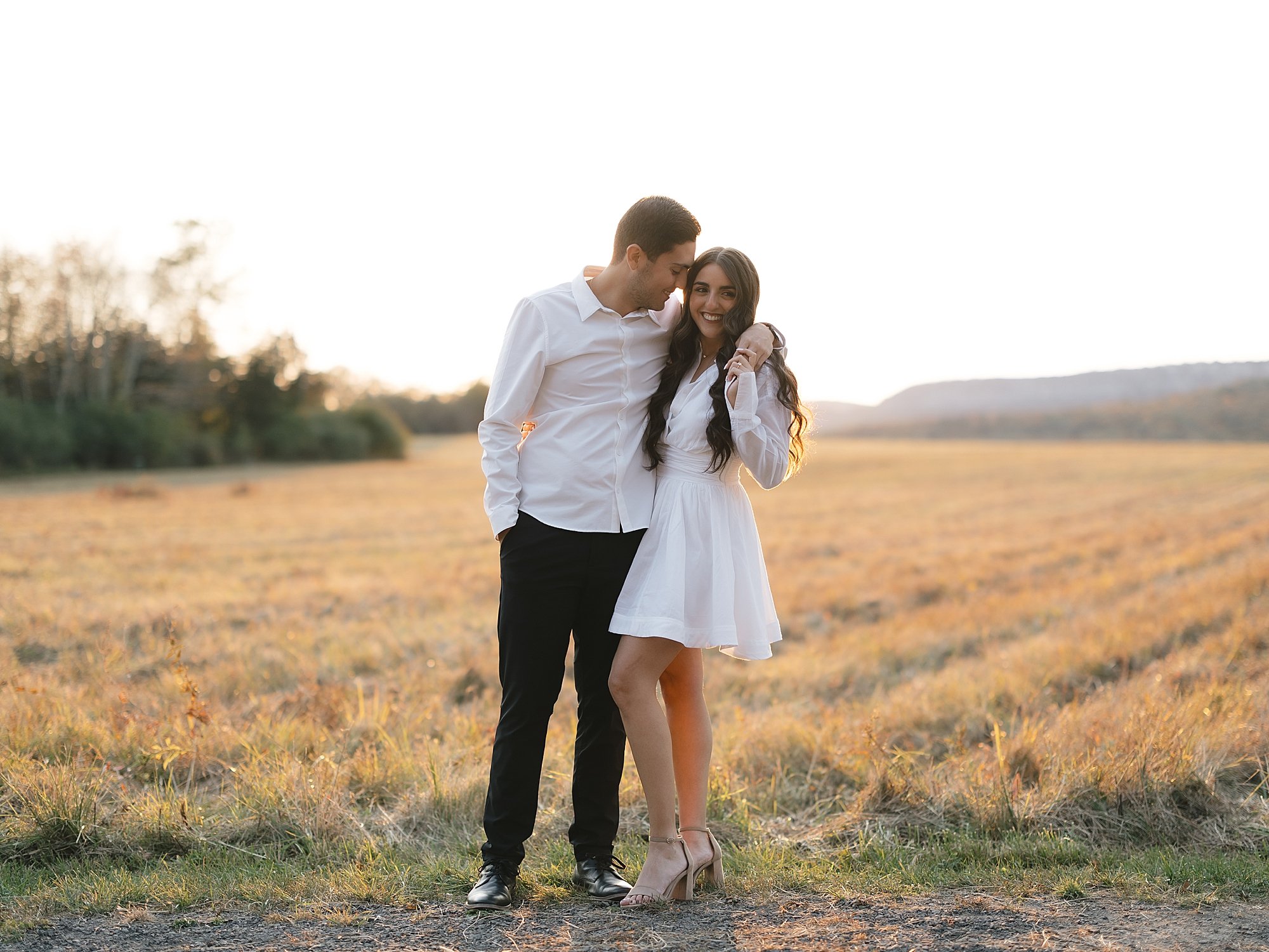 man hugs woman around shoulders leaning their heads together