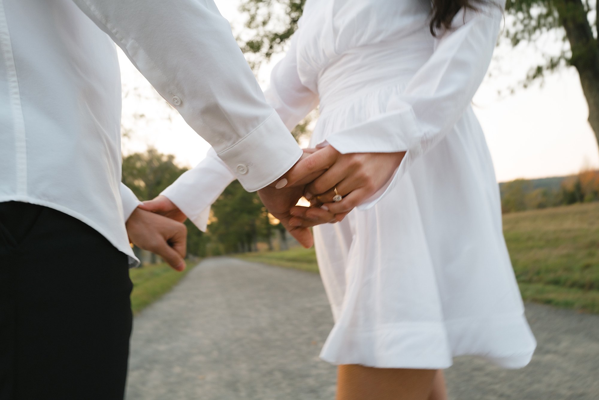 engaged couple holds hands showing woman's ring