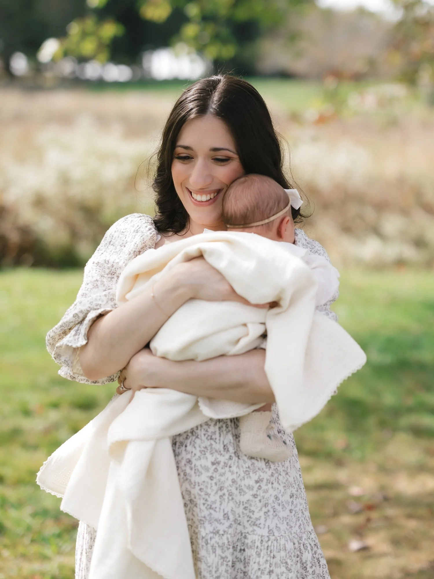 mother holds daughter against chest covered in blanket