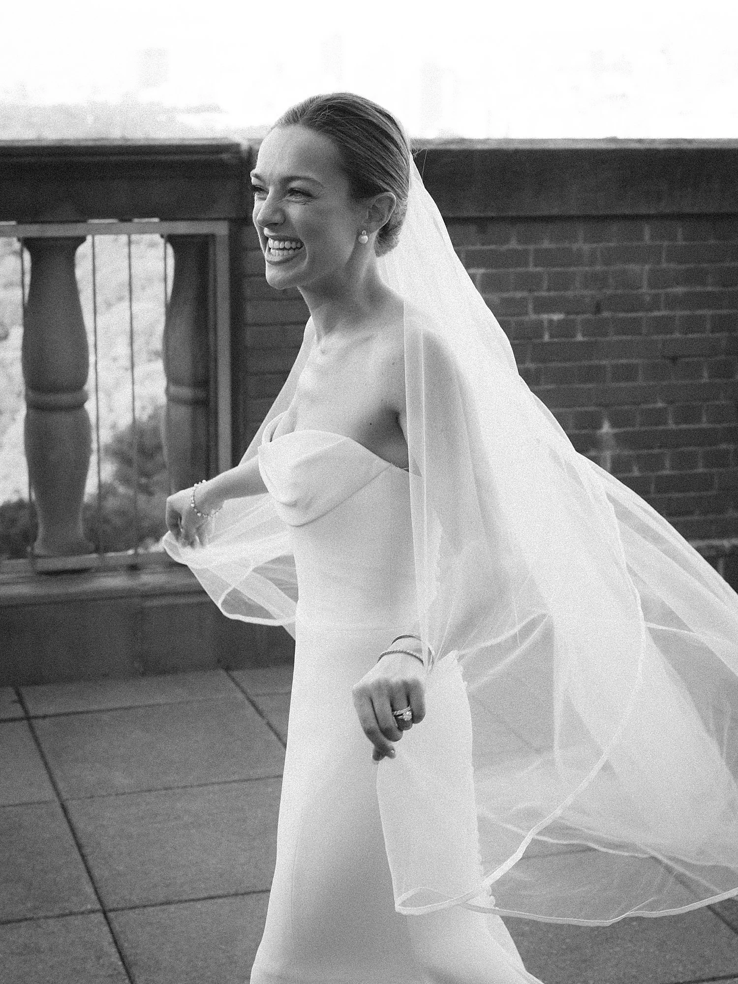 bride twirls on rooftop holding edge of veil at the New York Athletic Club