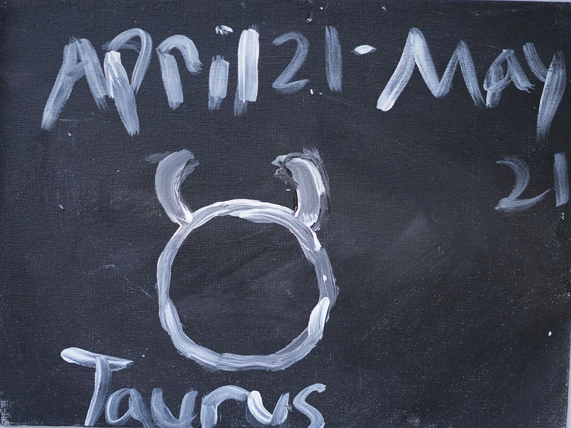 A blackboard with the date 'April 21, May 21' written at the top. Below, a dolphin's face is drawn with paint or chalk, with the word 'Dolphin' written underneath.
