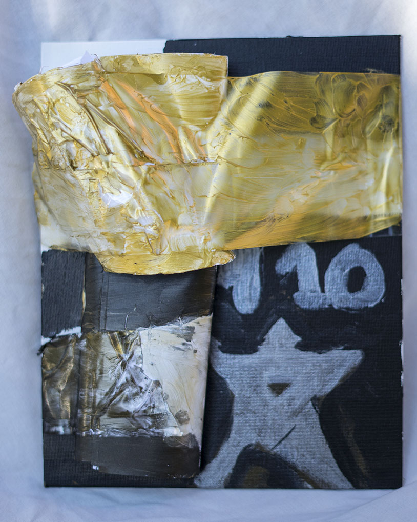 An abstract mixed media artwork featuring heavy brushstrokes with gold, black, white, and gray paint. The background includes a portion of a star and partial numbers, with the upper part dominated by textured gold paint.