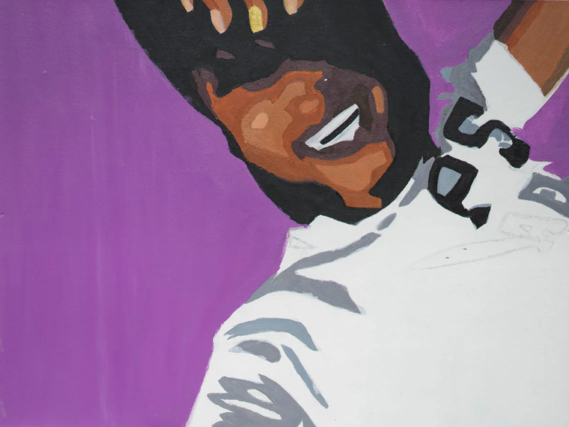 Close-up of a smiling person with dark hair, wearing glasses and a white jacket, set against a purple background.