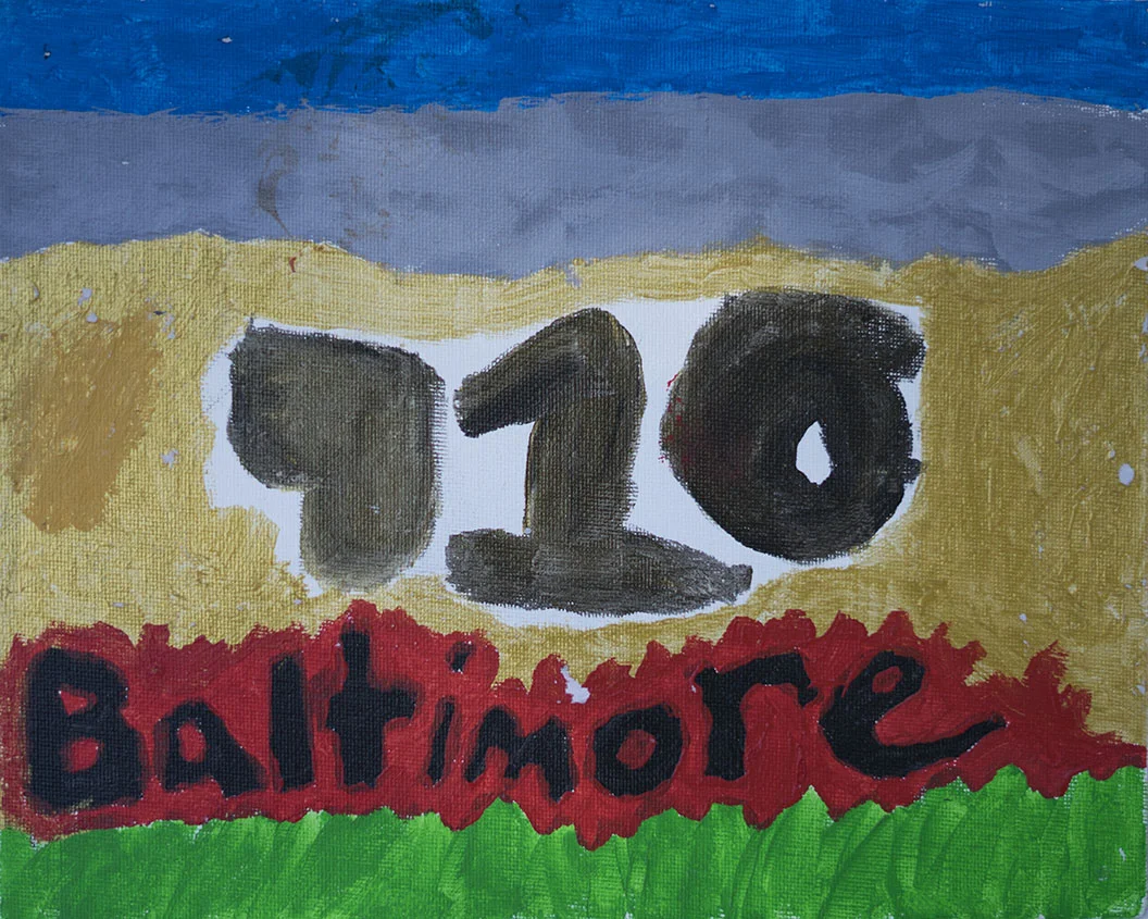 A painted banner with the number 10 in large black on a white background, the word Baltimore below it in black on a red background, and green grass at the bottom with a blue sky at the top.