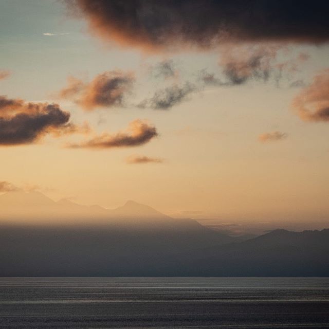 P A S T E L &gt;&gt; #Lombok peeks through the dawn view across the straight from #Amed on the north-east coast of #Bali - #thebalibible #indonesiageographic #indonesiatravel #dawn #view #beautiful #nature #exploremore #travel