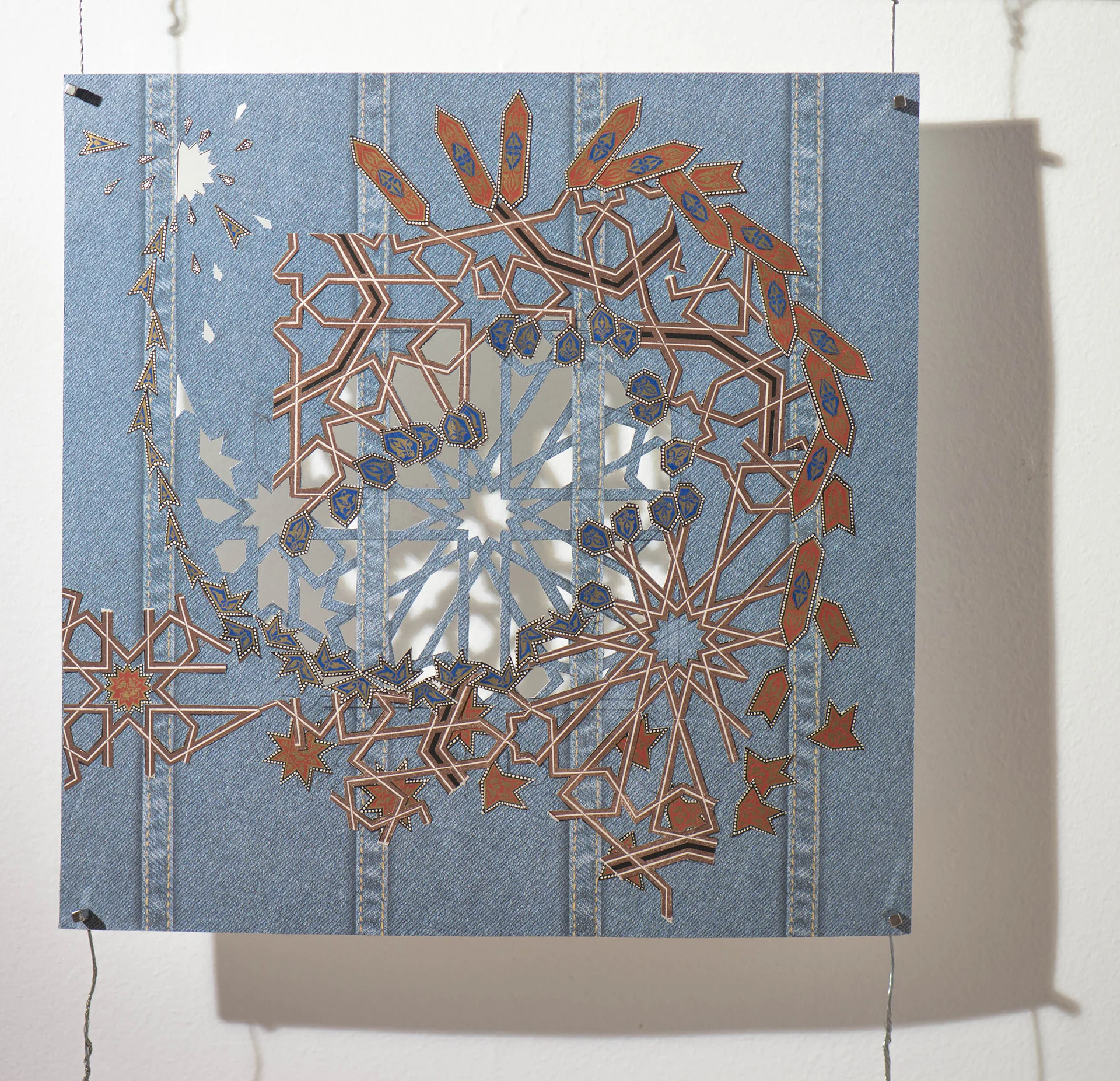These works using collage and paper cuts can be seen as a way of negotiating back and forth between two and three dimensions, a conversation that moves between the poles of image vs object, seduction vs consumption, value vs light, surface vs depth. The collages stem from two image sources, the first one is aerial, reflecting what I see as I fly back and forth over the country, looking down and ruminating about land use and morphology. The second source is a fine old printing of the Grammar of Ornament by Owen Jones. The pages, especially those of ancient and colonized cultures, drew me in. The printing quality made the pages feel more like objects than images. Placing these jewel-like swatches on faux denim felt like studying them in relation to American cultural territory. As I cut and pasted cultural history on to this ground, I listened to stories about refugees, racists, and Republican sound bites. I mulled over how to give voice to the conflict I feel about being an American right now in the world. I debated questions concerning cultural appropriation in my head as I worked.